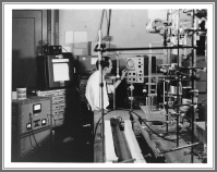 The main spectrometer in the NBS microwave lab in 1957, with David Lide operating the controls. Two waveguide absorption cells are in the bottom center; the left cell is in an insulated trough that could be cooled with dry ice. Stark modulation with an 80 kHz square wave was applied to a septum in the cells. Spectra were usually observed and measured on the oscilloscope, with the chart recorder used for fine details.